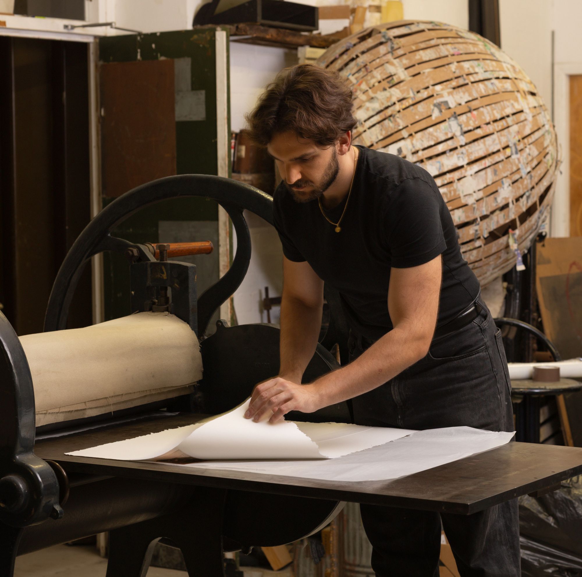 Leonardo Frigo lifting a freshly printed sheet from the etching press